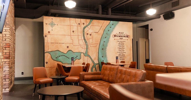 Interior, tables, upholstered leather chairs, and couches, mural map of 1889 Milwaukee