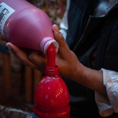 Pouring a bottle of red paint.
