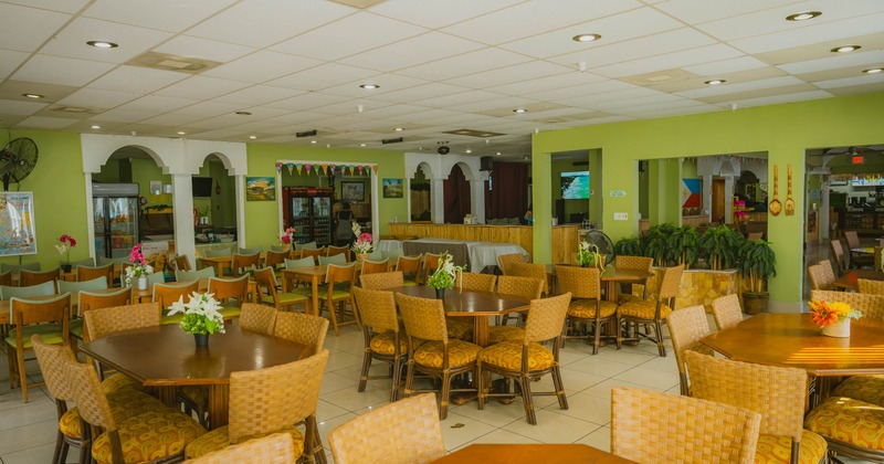 Interior seating area with wooden tables and wicker chairs