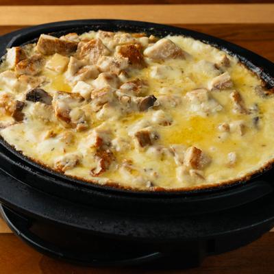 Bowl of Mexican melted cheese with chicken and mushrooms.