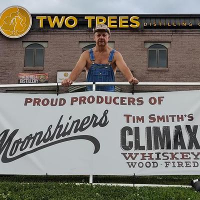 A person standing outside with the Two Trees building behind.