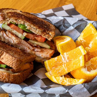 Tallahassee Turkey sandwich served with a side of orange slices.
