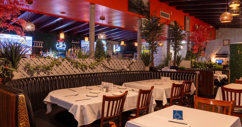 Interior, dining area, large ''U'' shaped booth with two tables, plant decoration