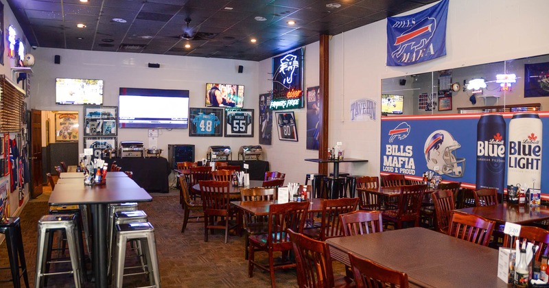 Interior, dining area, TVs and framed sports jerseys and pictures on walls