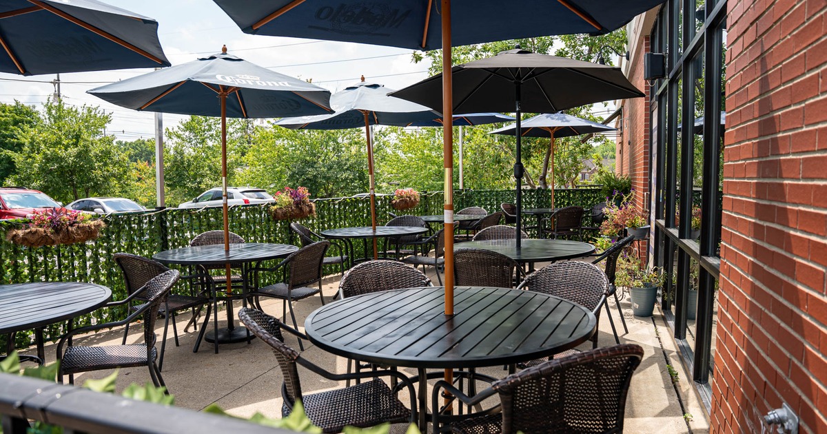 Exterior, patio, partially covered seating area, tables and chairs with parasols