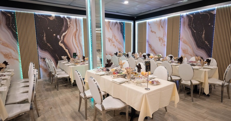Elegantly set dining room with abstract art walls and white chairs.
