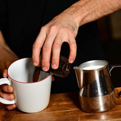 A barista preparing a coffee drink.