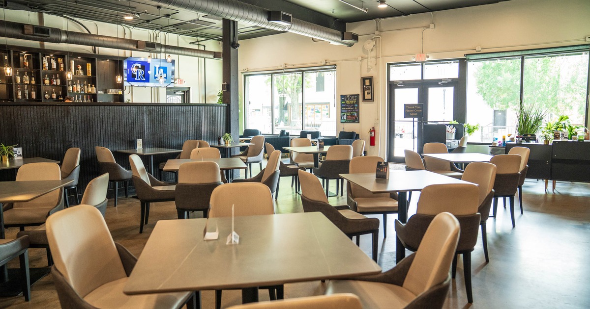 Modern restaurant interior with neutral-toned chairs and tables arranged neatly