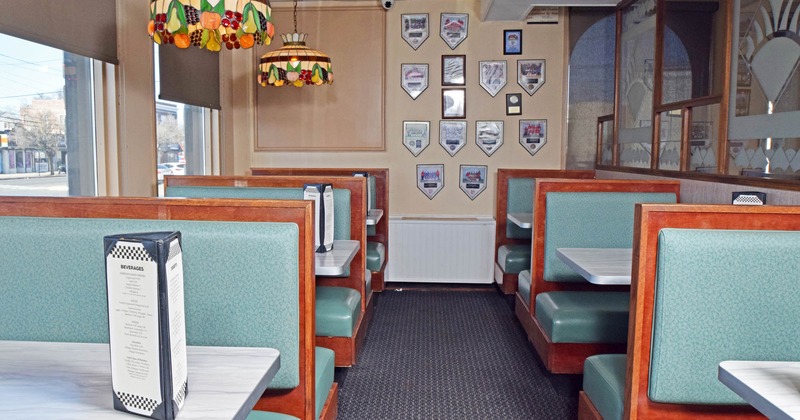 Interior, dining area, seating booths for four and two, windows with blinds, carpet flooring