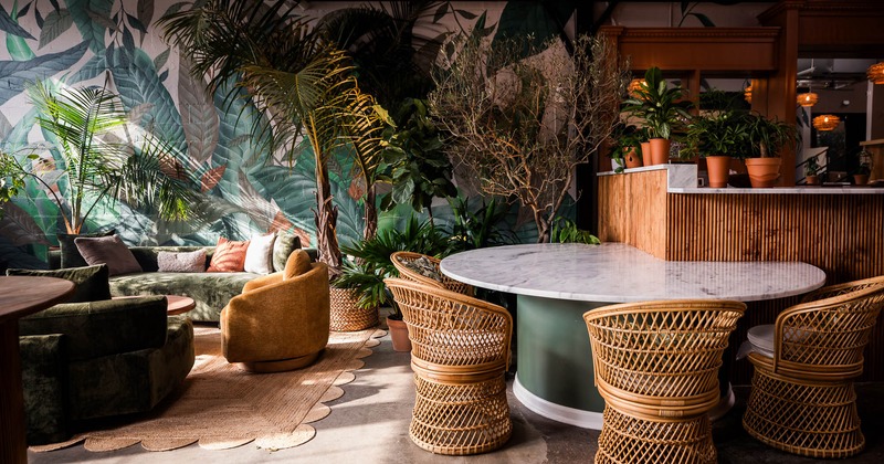 Interior, lounge area, sofas and armchairs, marble top table with four wicker chairs
