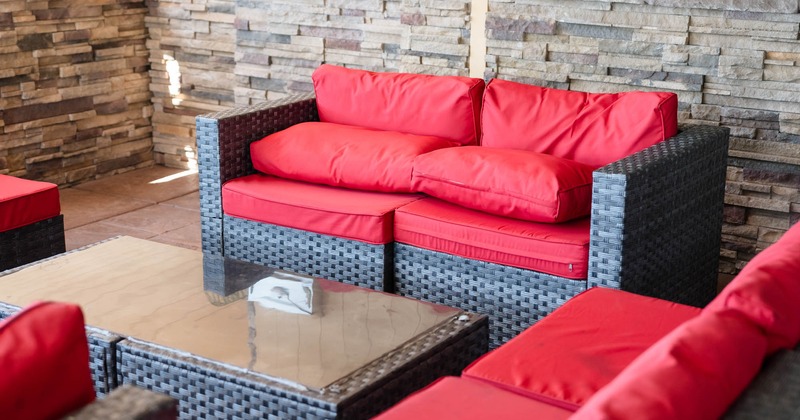 Outdoor seating area with wicker furniture and red cushions