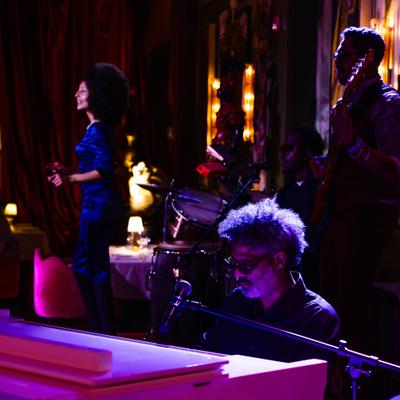 Live band performing at Calle Dragones, artwork behind the stage.