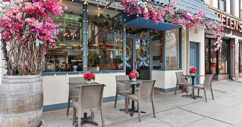 Exterior seating area with tables for two, floral decoration