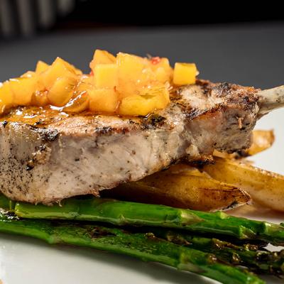 Pork Chop topped with apricot chutney, served with asparagus and potato wedges.