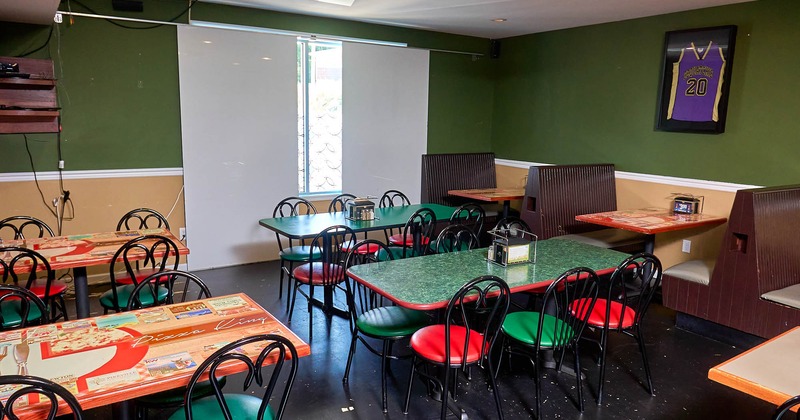 Interior, seating area, tables for six, seating booths by the wall, framed jersey