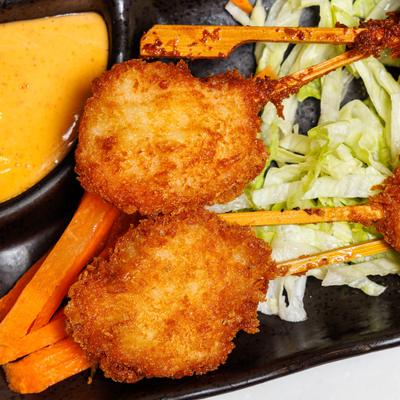 Shrimp Pops served over shredded lettuce and served with sauce, close-up.