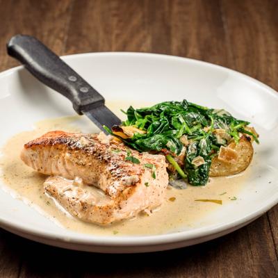 Pan-seared salmon served over sautéed baby spinach, roasted parmesan potatoes.