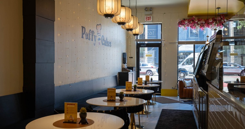 Interior, seating area, long banquette bench with round tables, entrance in the back