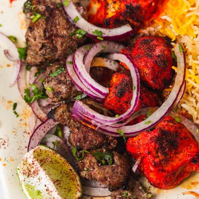 Combo Kabob Chicken and Lamb topped with onion, and rice.