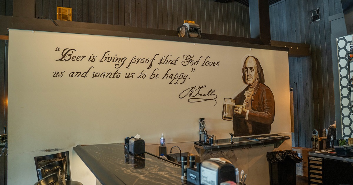 Bar, corner, stools, a quote from Benjamin Franklin about beer, written on the wall behind
