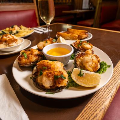 Stuffed scallops with a lemon wedge and melted butter, served alongside other dishes.
