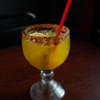 Margarita cocktail served in a goblet-style glass with a red straw.