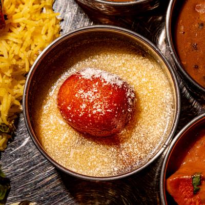 Gulab Jamun dessert served alongside other dishes.
