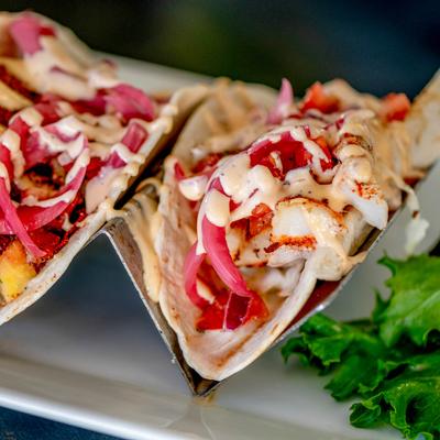 Tacos, with meat, coleslaw, pickled red onion, pico de gallo, and sriracha aioli.
