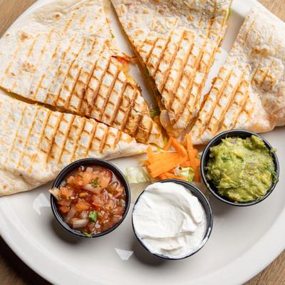 Chicken quesadilla served with salsa, sour cream, and guacamole.