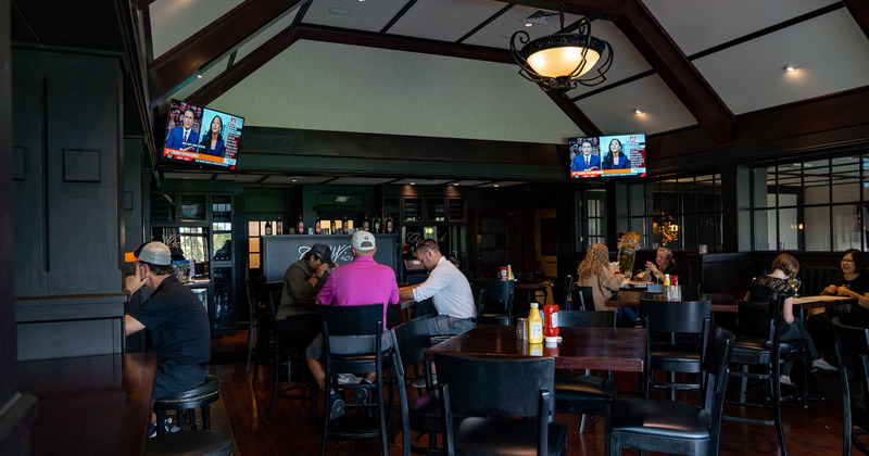 Main Room - guests enjoying themselves, two large TVs above