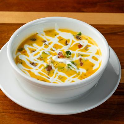 Bowl of melted cheese with ground beef, pico de gallo, and sour cream.