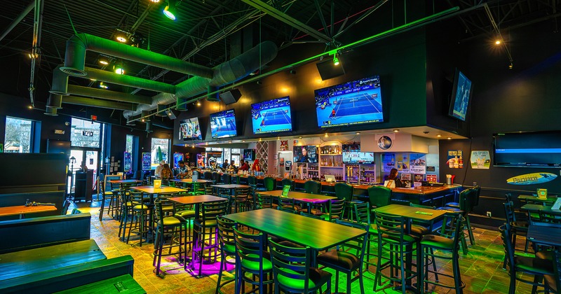 Spacious and cozy sports bar interior space, seating area and bar