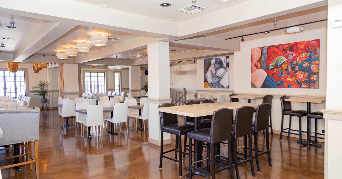 Spacious restaurant interior with tables, chairs, vibrant artwork