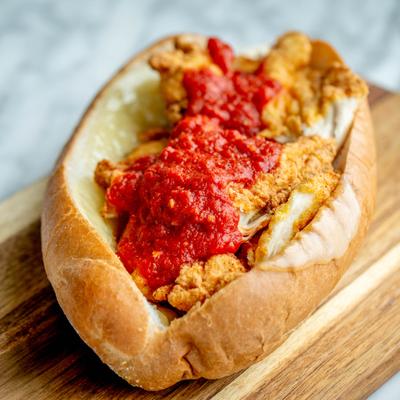 Chicken Parm Sub sandwich topped with tomato sauce.