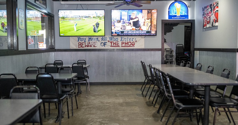 Interior, seating area, tables and chairs, TVs on the walll