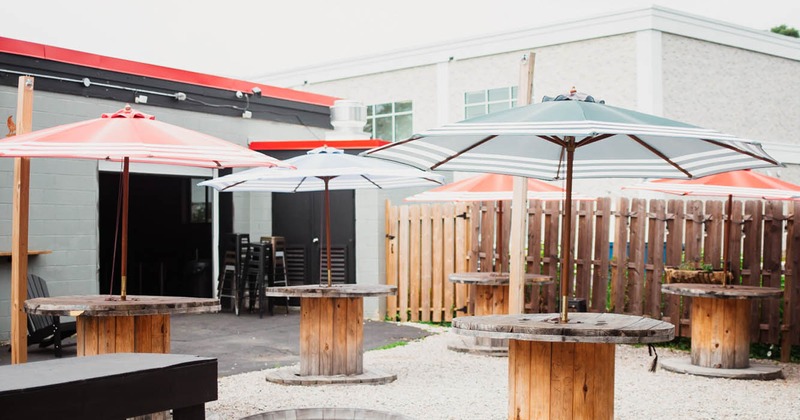 Exterior, wood spools used as tables, with parasols