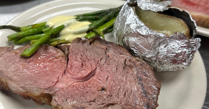 Prime rib steak served with asparagus and baked potato