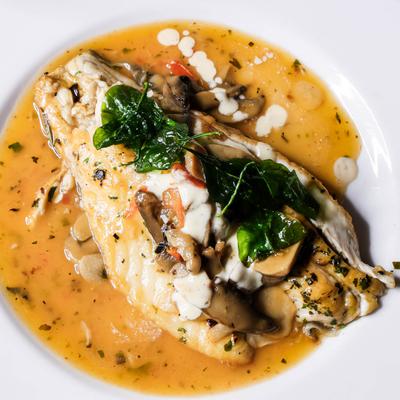 Asian Sea Bass with mushrooms, fire-roasted tomatoes and white wine garlic sauce.