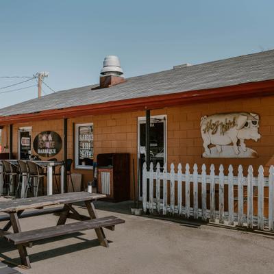 The exterior of Doko Smoke BBQ restaurant, with picnic table seating.