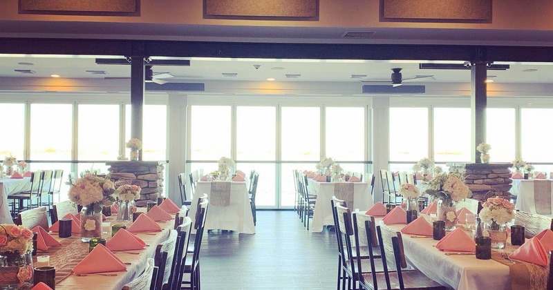 Inside, banquet hall with long tables, white tablecloths, pink napkins, and floral centerpieces