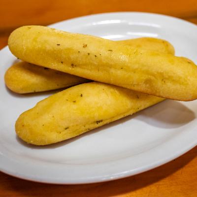 Garlic butter breadsticks served on a white plate.