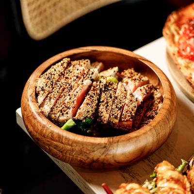 A serving of sesame crusted tuna in a wooden bowl.