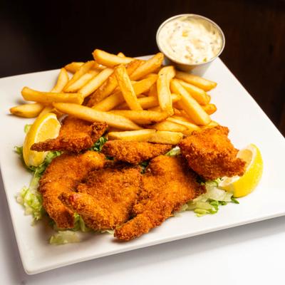 Fish and chips platter with fries, tartar sauce, and lemon wedges