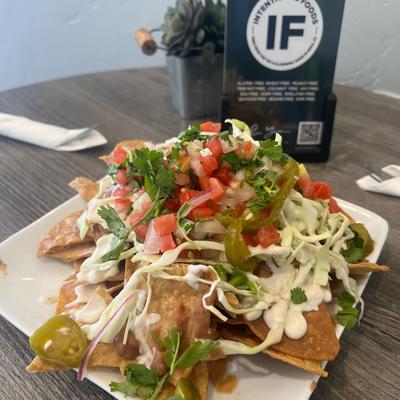 Nachos, with pico de gallo, jalapenos, cheese sauce, red onion, and cilantro.