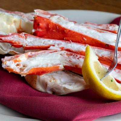 King crab legs served with a wedge of lemon, close-up.