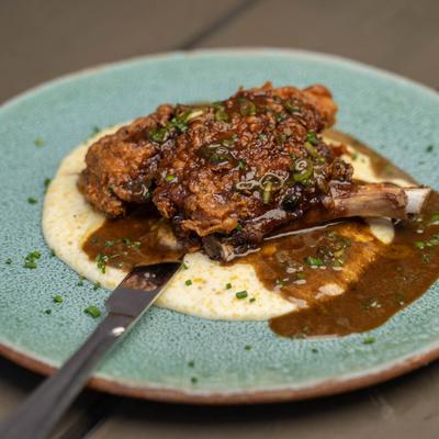 Bone in pork chop served with gravy and mashed potatoes