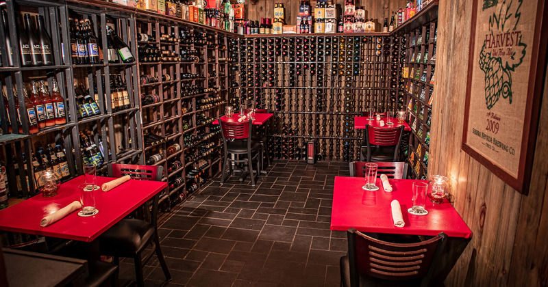 Tables ready for guests, shelves with bottles of drinks in the back