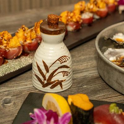 Sushi rolls and a sake bottle.