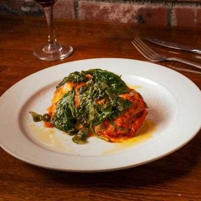 Lasagna topped with spinach.