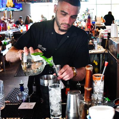 A bartender preparing a cocktail.